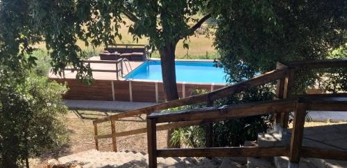 una piscina con una valla de madera junto a un árbol en La Finestra Sul Cortile en Pomezia