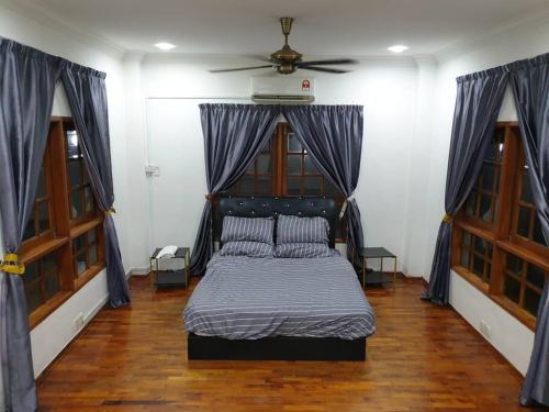 Nilai Spring Villas في نيلاي: غرفة نوم بسرير ومروحة سقف