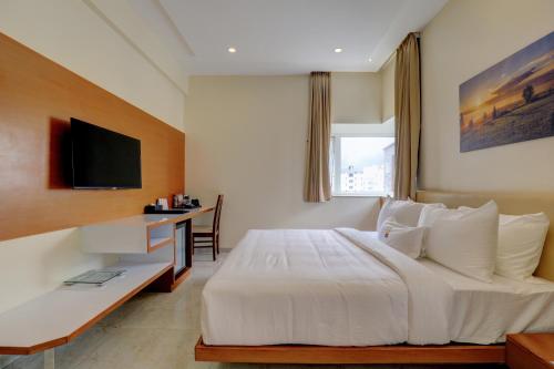 a bedroom with a large white bed and a desk at MySpace Tattwa Grand in Yelahanka