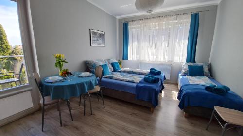 コウォブジェクにあるBela - pokoje z aneksami i apartamentyのベッドルーム1室(ベッド2台、テーブル、椅子付)