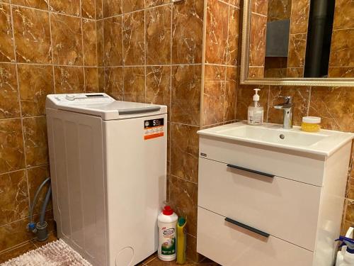 a small bathroom with a sink and a water heater at Happy rooms in Ventspils