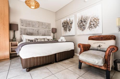 um quarto com uma cama grande e uma cadeira em Avemore Eikehof No 24 em Stellenbosch