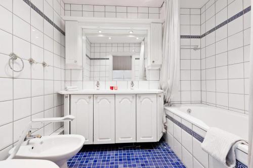 a white bathroom with a sink and a tub and a toilet at Villa Internationals Residence in Oslo