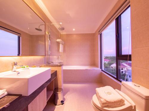a bathroom with a sink and a toilet and a tub at Prince Hotel in Yangon