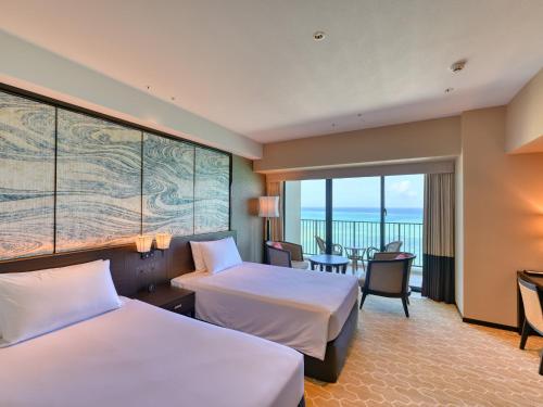 a hotel room with two beds and a balcony at Ryukyu Hotel & Resort Nashiro Beach in Itoman