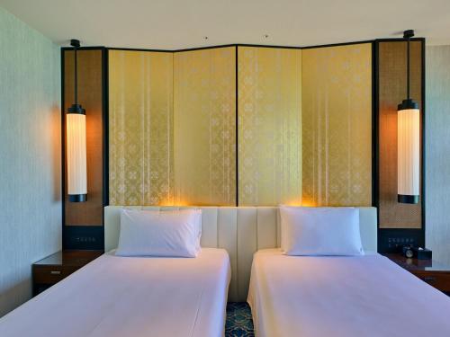 two beds sitting next to each other in a room at Ryukyu Hotel & Resort Nashiro Beach in Itoman