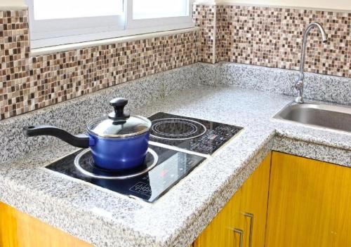 a pot sitting on top of a stove in a kitchen at Laciaville Resort and Hotel in Mactan