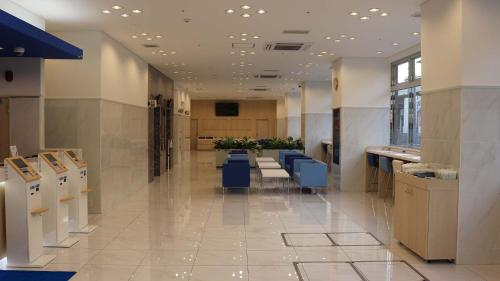 a lobby with a waiting room with blue chairs at Toyoko Inn Saga Ekimae in Saga