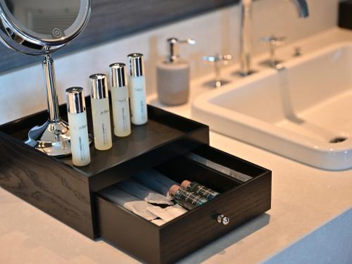a bathroom vanity with a black box with toothbrushes at Ryukyu Hotel & Resort Nashiro Beach in Itoman