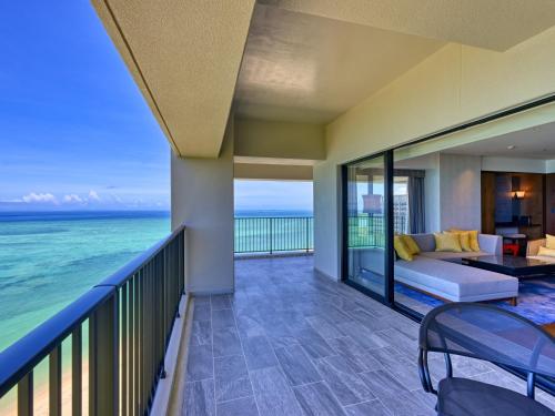 a balcony with a couch and a view of the ocean at Ryukyu Hotel & Resort Nashiro Beach in Itoman