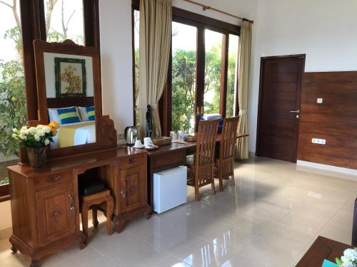 a bedroom with a desk with a mirror and a bed at Meditasi Bungalows & Villas in Amed