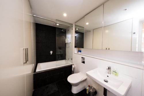 a bathroom with a sink and a toilet and a mirror at Alora Apartment in Sydney CBD - Darling Harbour in Sydney