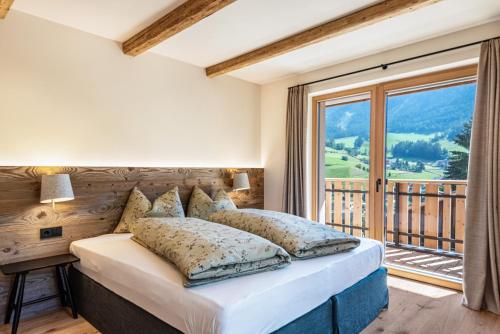 a bedroom with a bed and a large window at Lippmöshof Apartment Odla in Villnoss