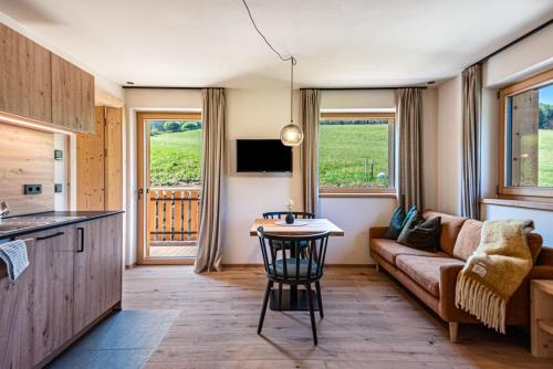 a kitchen and living room with a couch and a table at Lippmöshof Apartment Odla in Villnoss