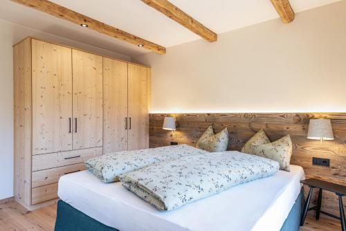 a bedroom with a large bed and a wooden wall at Lippmöshof Apartment Odla in Villnoss