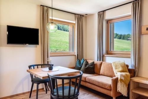 a living room with a couch and a table at Lippmöshof Apartment Odla in Villnoss