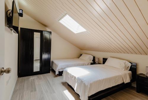 Schlafzimmer im Dachgeschoss mit 2 Betten und einem Dachfenster in der Unterkunft Elegant 2-bedroom apartment 2 km from Eagle beach in Palm-Eagle Beach