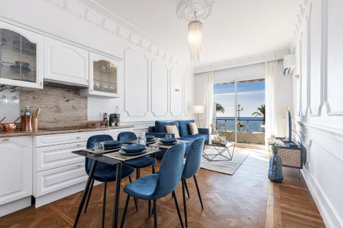 - une cuisine avec une table et des chaises bleues dans la chambre dans l'établissement PROMENADE SEA VIEW - Terrasse vue mer, à Nice