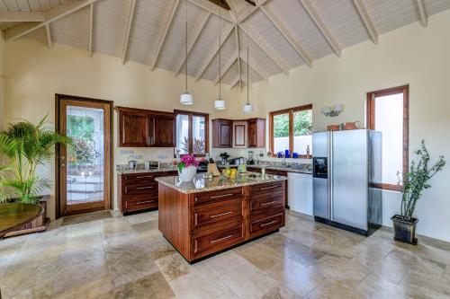 a large kitchen with wooden cabinets and a stainless steel refrigerator at Sadewa Villa in Port Elizabeth