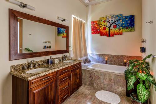 a bathroom with a sink and a tub and a mirror at Sadewa Villa in Port Elizabeth