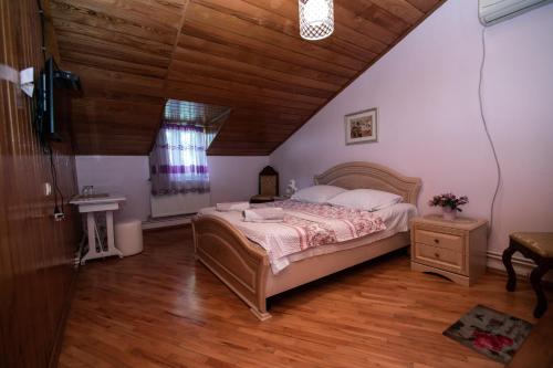 a bedroom with a large bed and a wooden ceiling at Family Hotel Lago & Wine Cellar in Lagodekhi