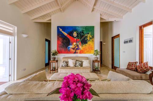 a living room with couches and a painting on the wall at Sadewa Villa in Port Elizabeth