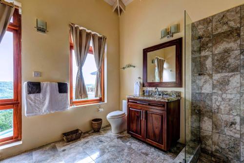 a bathroom with a shower and a toilet and a sink at Sadewa Villa in Port Elizabeth