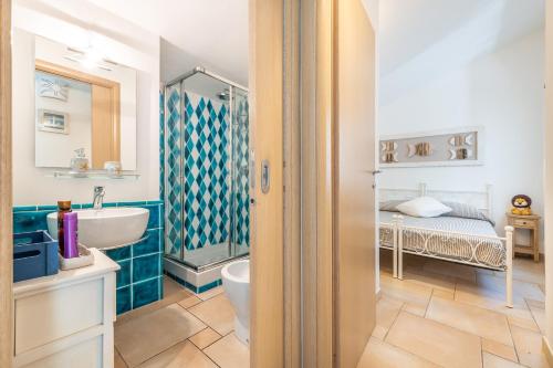 a bathroom with a sink and a toilet and a bed at Casa Vacanza Il Bouganville in Villasimius
