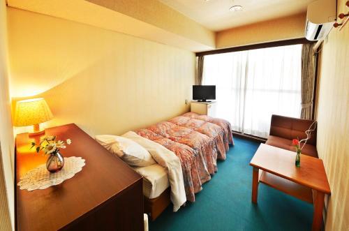 a hotel room with a bed and a desk at Sunriver Oboke in Miyoshi