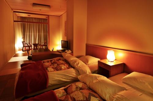 Habitación de hotel con 2 camas y mesa en Sunriver Oboke, en Miyoshi