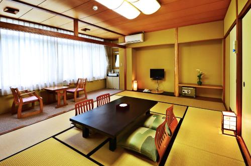 a large living room with a table and chairs at Sunriver Oboke in Miyoshi