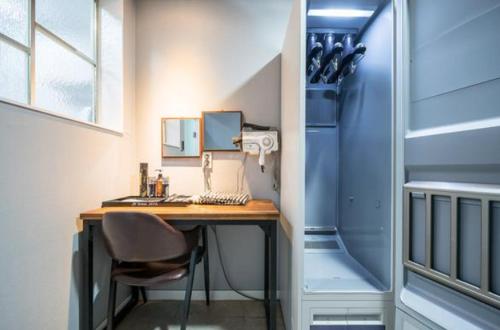a room with a desk with a chair and a refrigerator at Java Hotel in Gwangyang