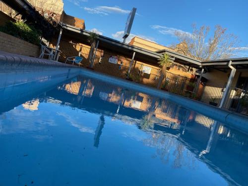 een zwembad van blauw water voor een hek bij Gateway Motor Inn in Narrandera
