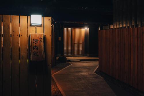 a dark hallway with a gate and a door with writing on it at 河内家 in Fujikawaguchiko