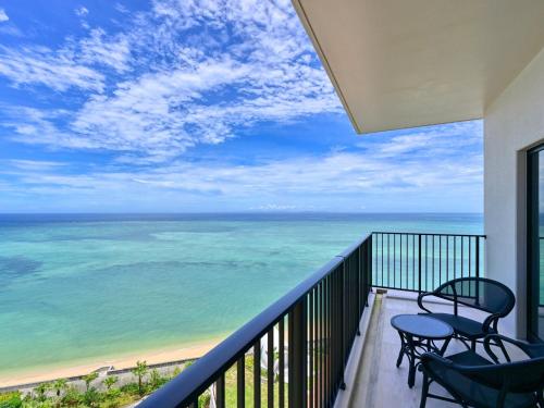 a balcony with chairs and a view of the ocean at Ryukyu Hotel & Resort Nashiro Beach in Itoman