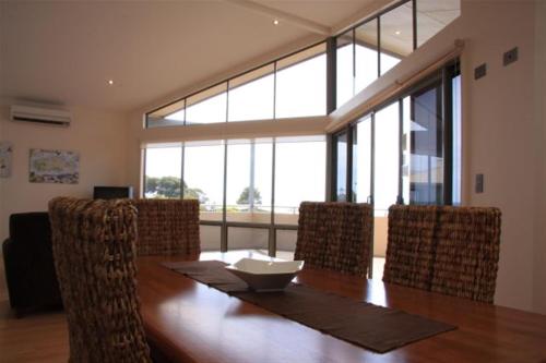 a dining room with a wooden table and chairs at Birubi Holiday Homes Kangaroo Island in Emu Bay