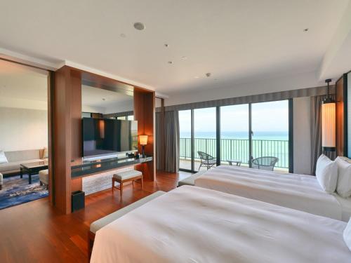 a hotel room with two beds and a view of the ocean at Ryukyu Hotel & Resort Nashiro Beach in Itoman
