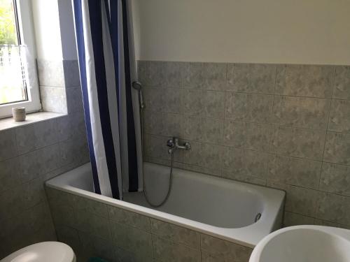 a bathroom with a bath tub and a toilet at Harmony 