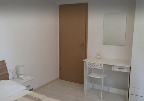 - une chambre avec un lit, un bureau et un miroir dans l'établissement Apartment Kozarica 4950b, à Kozarica