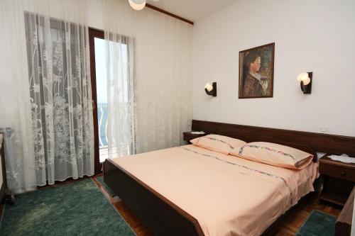 a bedroom with a bed and a large window at Apartment Drvenik Gornja vala 4890a in Drvenik