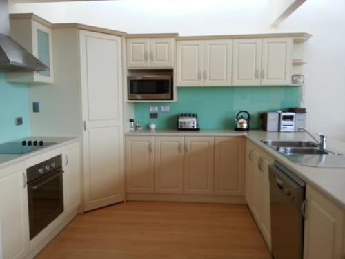 a kitchen with white cabinets and a counter top at Birubi Holiday Homes Kangaroo Island in Emu Bay