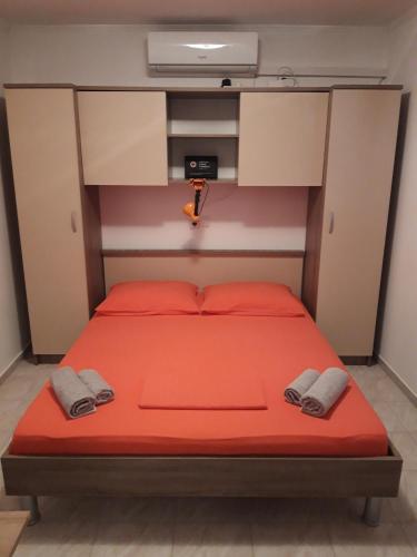 a bed with red sheets and a tv on top at Apartment Blaca 4899e in Maranovići