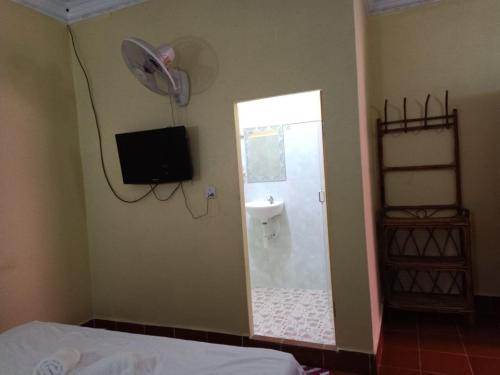 a bedroom with a bathroom with a shower and a television at Pina House in Kep