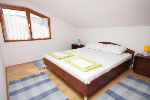 a bedroom with a bed with white sheets and a window at Apartment Gradac 6819a in Gradac