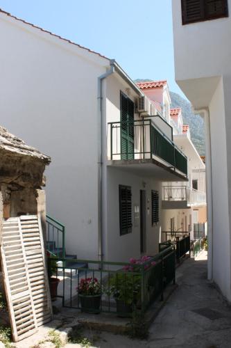a white building with a staircase and a balcony at Apartment Zaostrog 6659a in Zaostrog