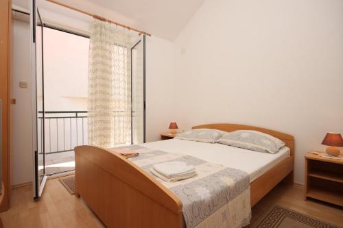 um quarto com uma cama e uma grande janela em Apartment Zaostrog 6659a em Zaostrog