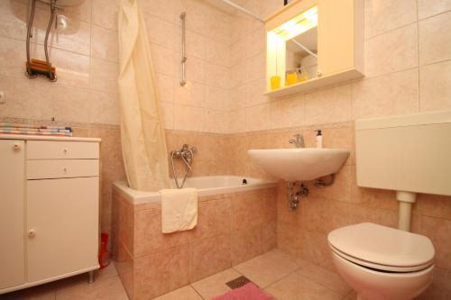y baño con aseo, lavabo y bañera. en Apartment Tucepi 6901a en Tučepi