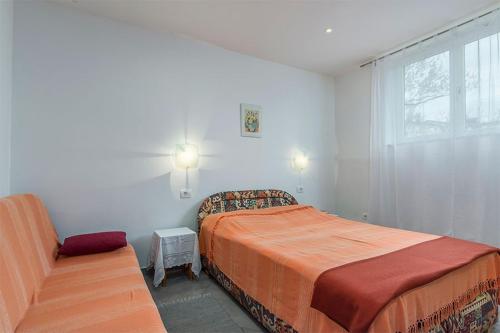 a bedroom with a bed and a chair and a window at Studio Novigrad 2536b in Novigrad Istria