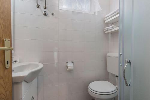 a white bathroom with a toilet and a sink at Studio Novigrad 2536b in Novigrad Istria