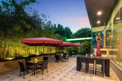 a patio with tables and chairs and umbrellas at Holiday Inn Shanghai Hongqiao Central by IHG in Shanghai